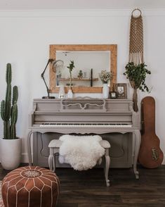 a living room filled with furniture and a piano in front of a mirror on the wall