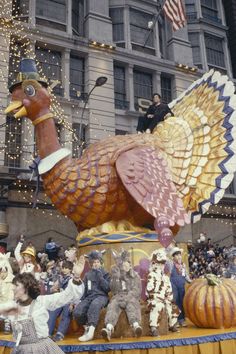 a parade float with people dressed in costumes and turkeys on it's back