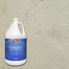 a gallon of liquid sitting on top of a cement wall