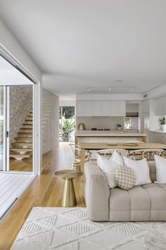 a living room filled with furniture next to a kitchen