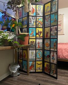 a room divider made out of comic book pages and potted plants on the floor