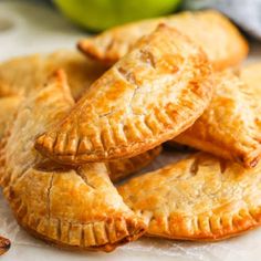 apple hand pies on a plate with cinnamon sticks and green apples in the background