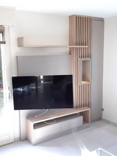 a flat screen tv sitting on top of a wooden shelf