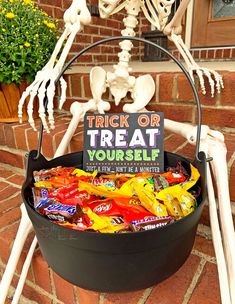 a trick or treat bucket filled with halloween candies and skeleton decorations on the front porch