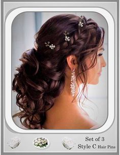 the back of a woman's head with flowers in her hair and earrings on it