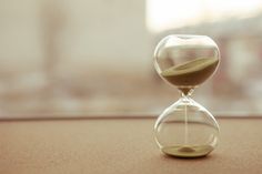 an hourglass sitting on top of a table next to a window