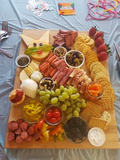 a wooden cutting board topped with lots of different types of food and condiments