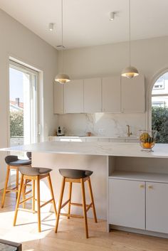 two stools sit at the center of a kitchen island