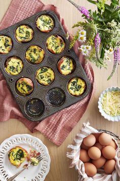 muffins with spinach and cheese are on a tray next to some flowers