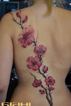 a woman's back with pink flowers on it