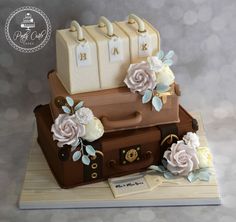 there is a cake made to look like two suitcases and flowers on top of each other