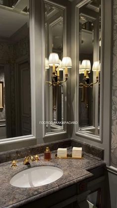 a bathroom sink sitting under two mirrors next to a wall mounted faucet with lights on it