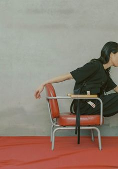 a woman sitting on top of a red chair