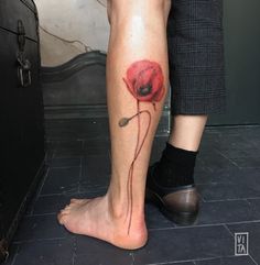 a person with a tattoo on their leg that has a red flower on the side