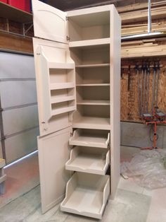 an empty storage cabinet in the middle of a room with no doors and shelves on each side