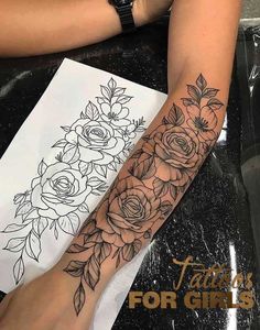 a woman's arm with flowers on it and a drawing in the back ground