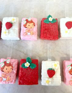 strawberry shortcakes are hanging from strings with strawberries on them, and decorated with fondant