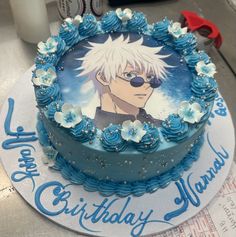 a birthday cake decorated with an anime character on the top and blue frosting flowers