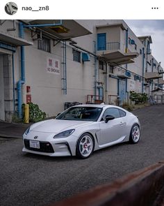 a white sports car parked in front of a building