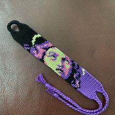 a purple and black beaded lanyard with a woman's face on it