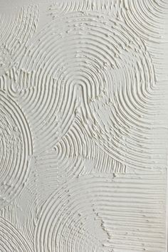 the textured wallpaper is white and has wavy lines on it's surface