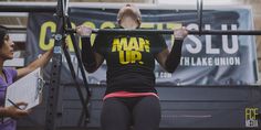 a woman is doing an overhead bar exercise