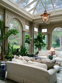 a living room filled with white furniture and lots of windows on top of each other