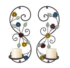 two metal wall sconces with flowers and leaves on them, one holding a candle