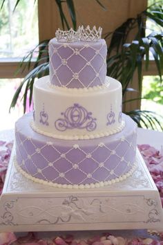 a three tiered cake with purple and white frosting