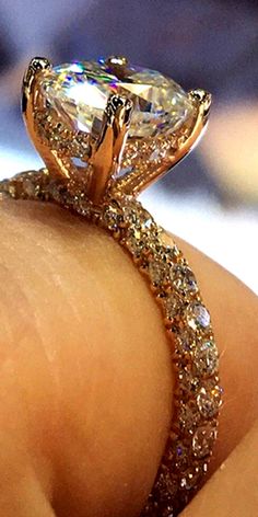 a close up of a person's hand with a diamond ring on their finger