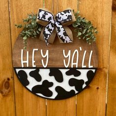 a sign that says hey y'all with a bow on it and some plants