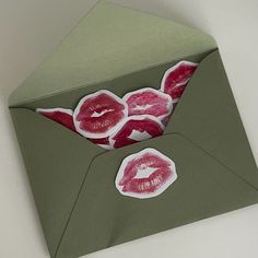 an open envelope with stickers on it and some lips sticking out of the inside