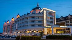 the hotel is lit up at night with colorful lights on it's roof and windows