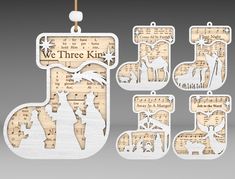 christmas ornaments made out of sheet music with the words, we three kings and two giraffes