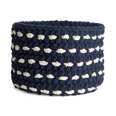 a crocheted basket with white and black dots on the outside, in front of a white background