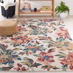 a white rug with colorful flowers on it in a room next to a book shelf