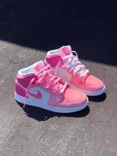 a pair of pink and white shoes on the ground