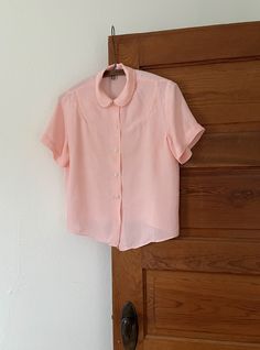 Sweet pink cold rayon blouse with button closure down the front, and sawtooth trim detail on collar and shoulder.  Condition: Discoloration on back.  shoulder: 15" pit to pit: 20" length: 22" Classic Pink Collared Top, Classic Pink Tops With Collared Neckline, Vintage Lace Collar Button-up Top, Retro Blouse With Peter Pan Collar For Vintage Fashion, Vintage Collared Blouse With Placket, Vintage Pink Blouse For Daywear, Pink Vintage Blouse For Daywear, Vintage Spring Blouse With Collared Neckline, Vintage Button-up Blouse With Placket