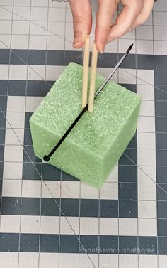 someone is using two chopsticks to cut into a green block