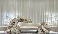 a white couch sitting next to a table with flowers on it