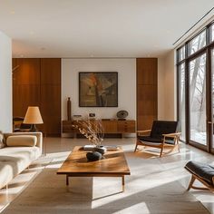 a living room filled with furniture and lots of windows next to a wooden coffee table