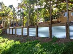 a row of white garage doors sitting on top of a lush green field