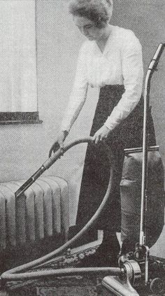 an old photo of a woman cleaning the floor with a vacuum and steam mop