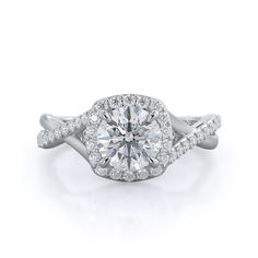 a diamond engagement ring with twisted shans on the band and an oval center stone surrounded by round brilliant pave diamonds