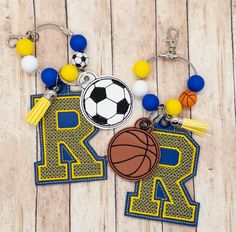 a sports themed keychain with a basketball, soccer ball and letter k on it