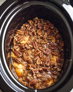 the food in the slow cooker is ready to be cooked and eaten with pecans