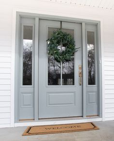 a gray front door with a wreath on it