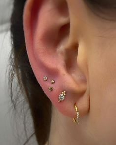 a close up of a person's ear with three different types of piercings