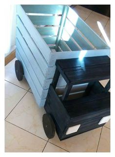 two wooden crates sitting on top of a tile floor next to each other with wheels