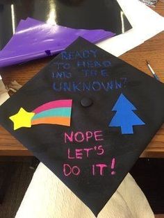 a graduation cap that has been decorated with rainbows and stars on it, reading ready to read no the unknown? nope let's do it